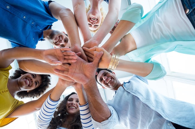 Team putting their hands together in circle