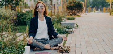 Employee enjoying mindfulness in a garden with notebooks and coffee, reflecting the benefits of EAP services for work life balance